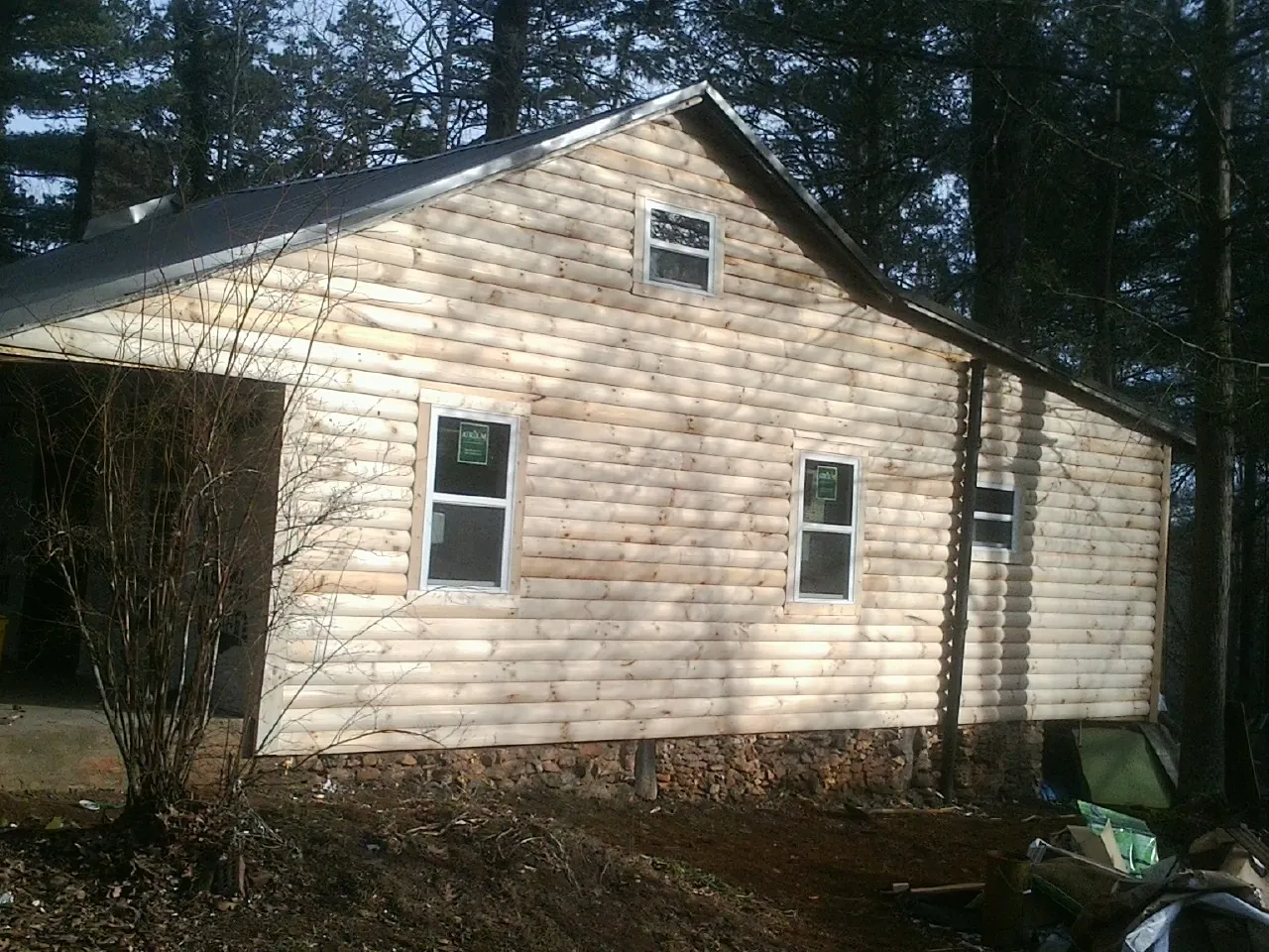 New log siding and dark metal roofing on a gable end in Holland